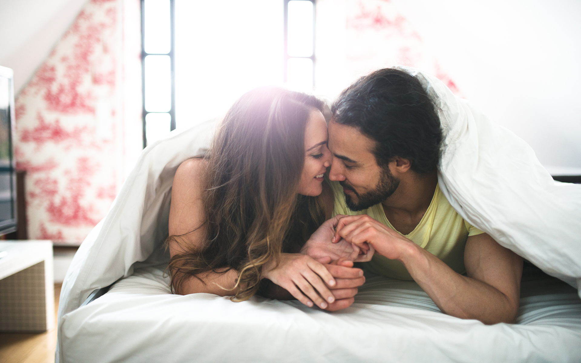 couple kissing on the bed on early morning