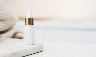 A small white bottle on the corner with a white towel