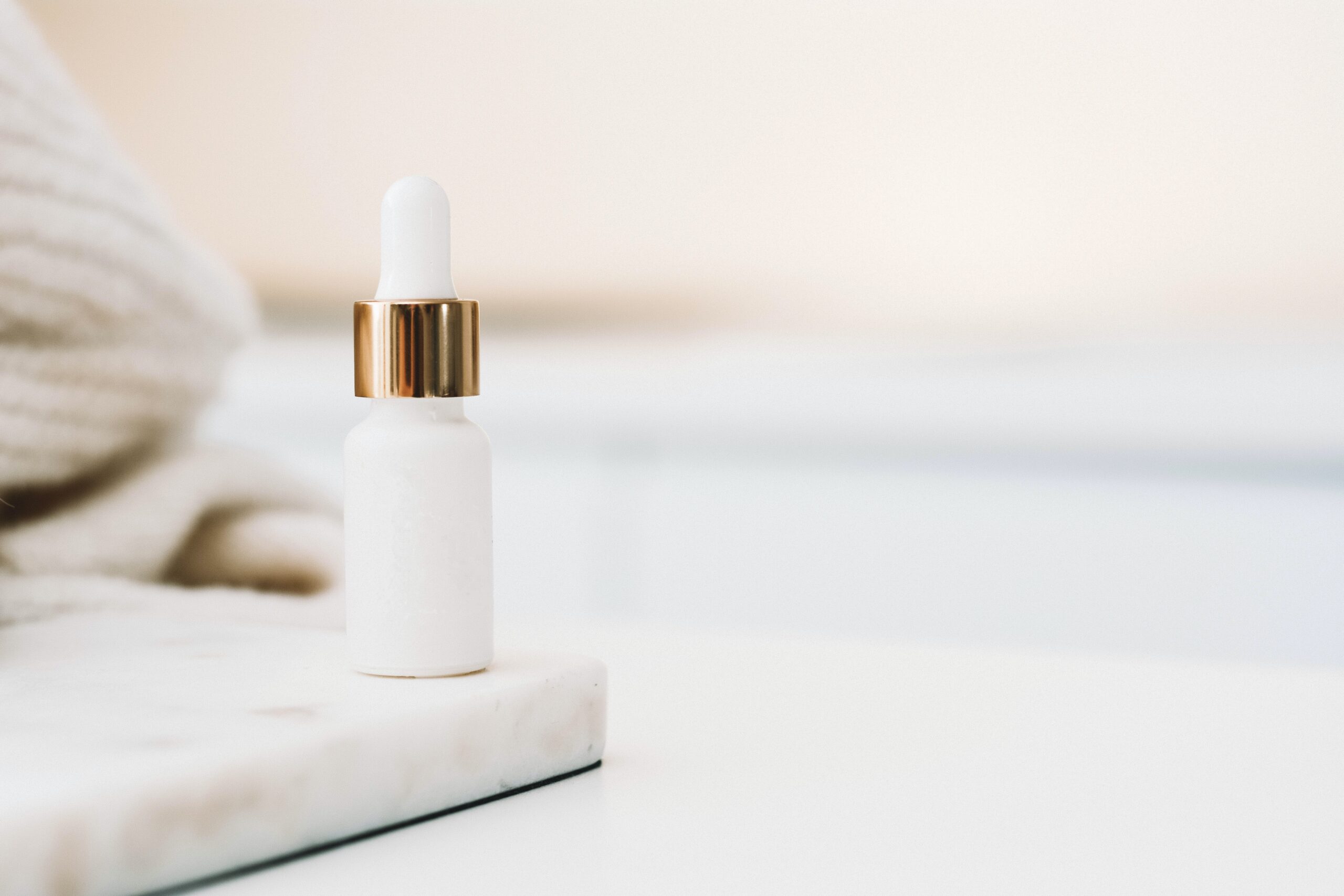 A small white bottle on the corner with a white towel