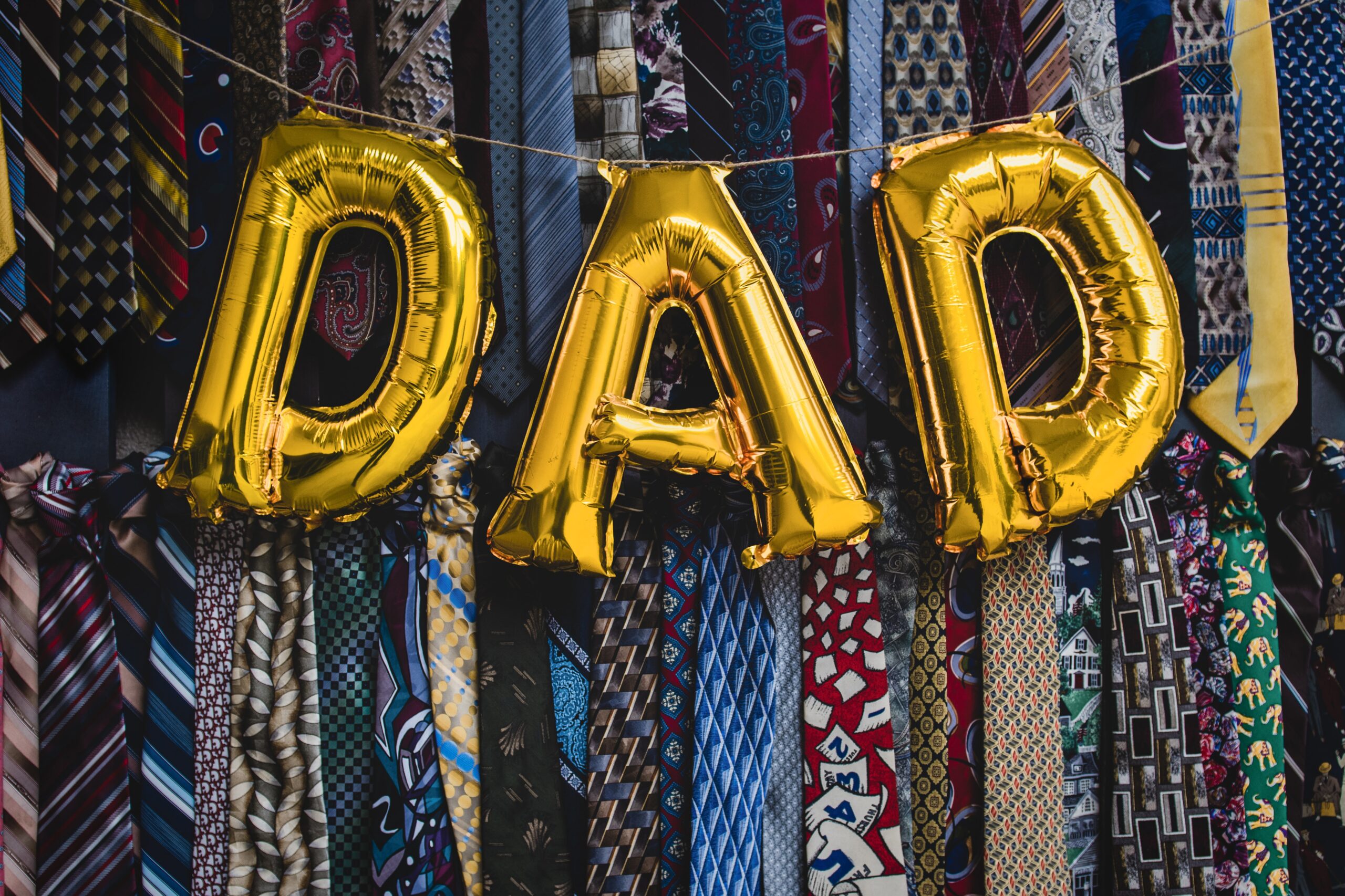 Balloons spell out DAD hang over a selection of men's ties