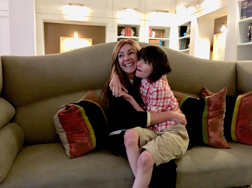Mother and son hug on the couch at home