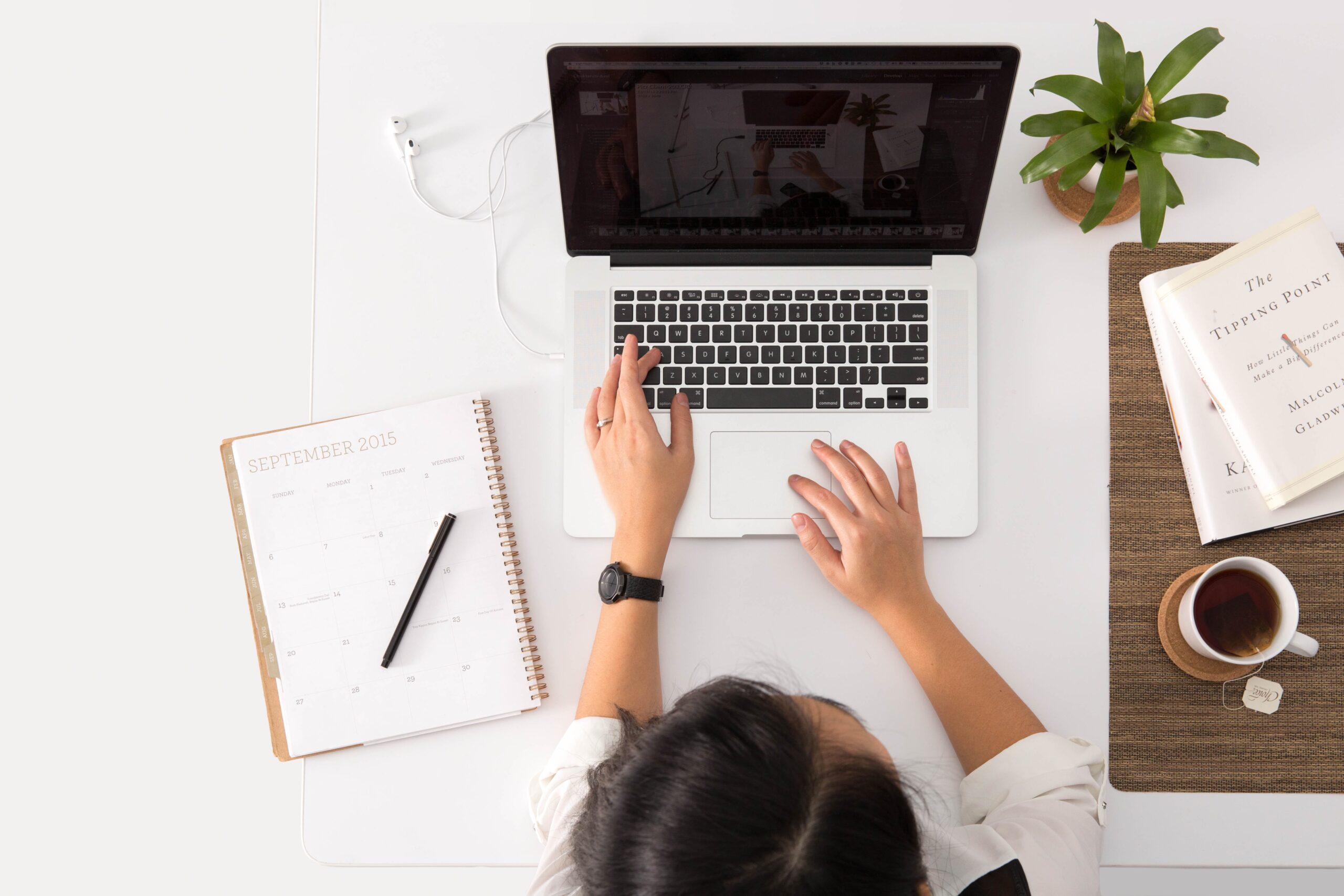 Woman with a laptop studying and making notes