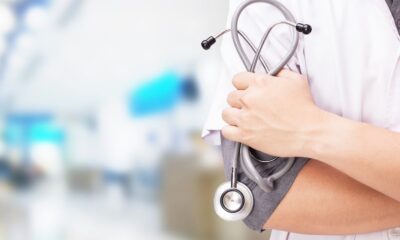 Person in white coat holding stethoscope