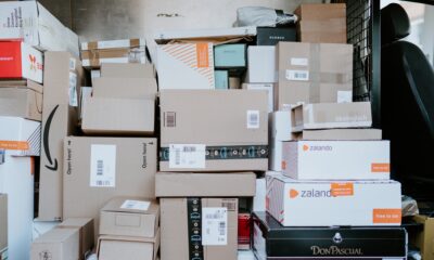 Parcels packaged in mixed colours of cardboard stacked in the back of a van for delivery