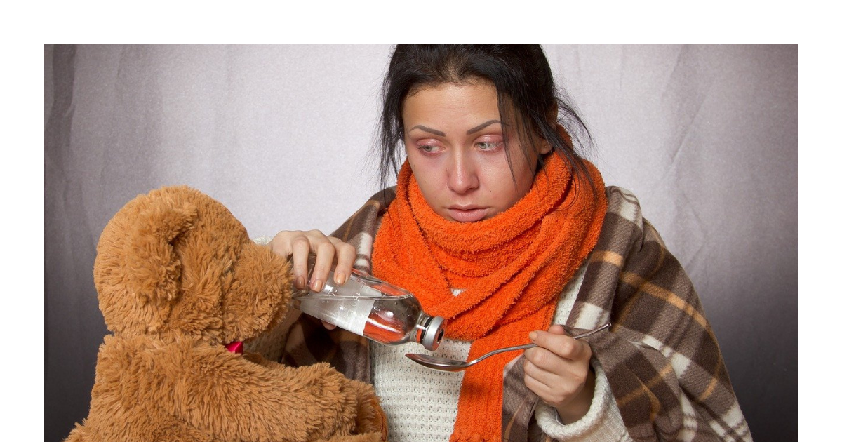 Woman taking medicine from a spoon