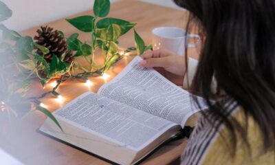 A woman studying a book with fairy lights