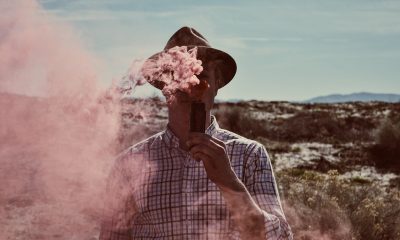 Man in checked shirt vaping outdoors