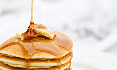 A stack of panckaes with butter and syrup.