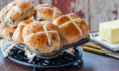 Hot Cross Buns on a plate with some butter.