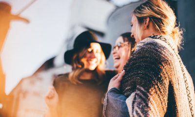 Women standing together, laughing and celebrating in the sunshine