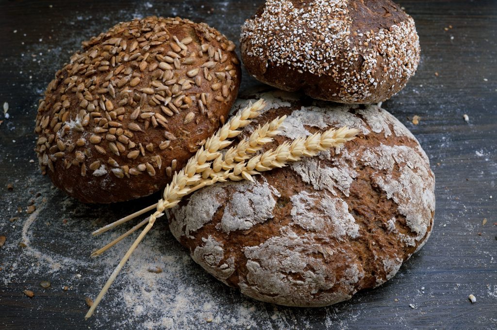 Three loaves of soda bread with three grains lying across them to highlight coeliac awareness week