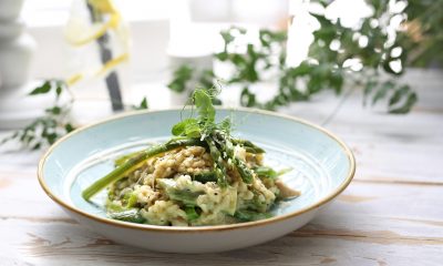 Risotto in a dish on a table. Decorated with foliage.