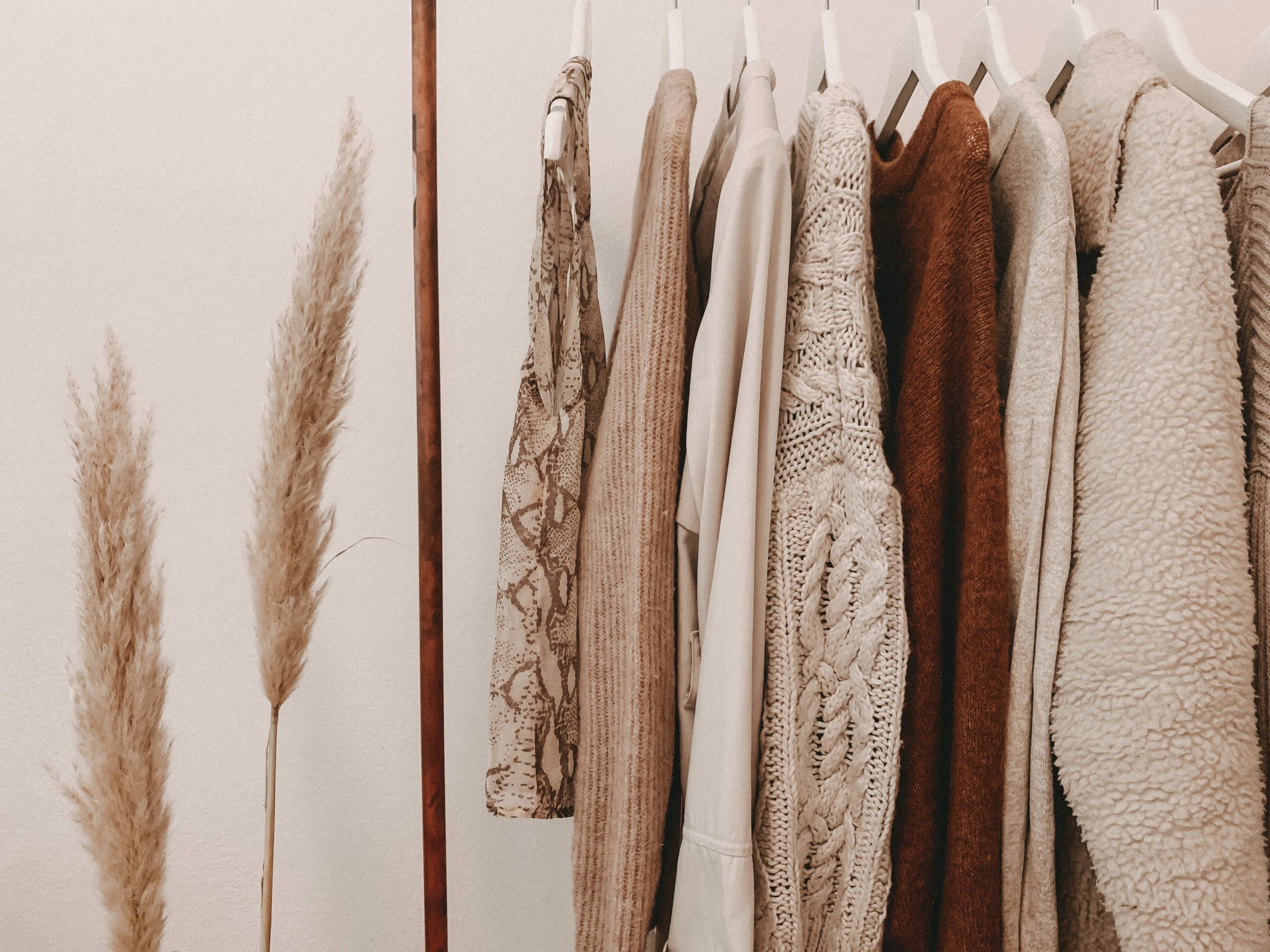 A row of hemp fashion hanging on a rail in beige and brown tones