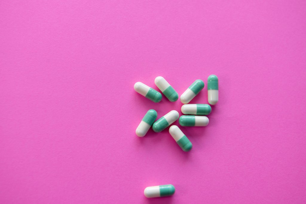 Blue and white pills on a bright pink background