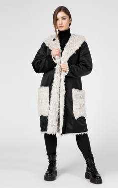 A woman wearing a black and white coat with a hemp fur trim.