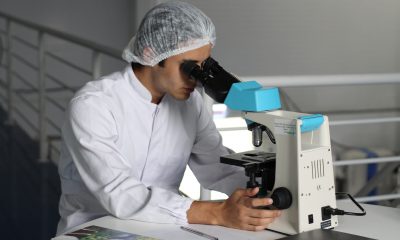 White man using microscope