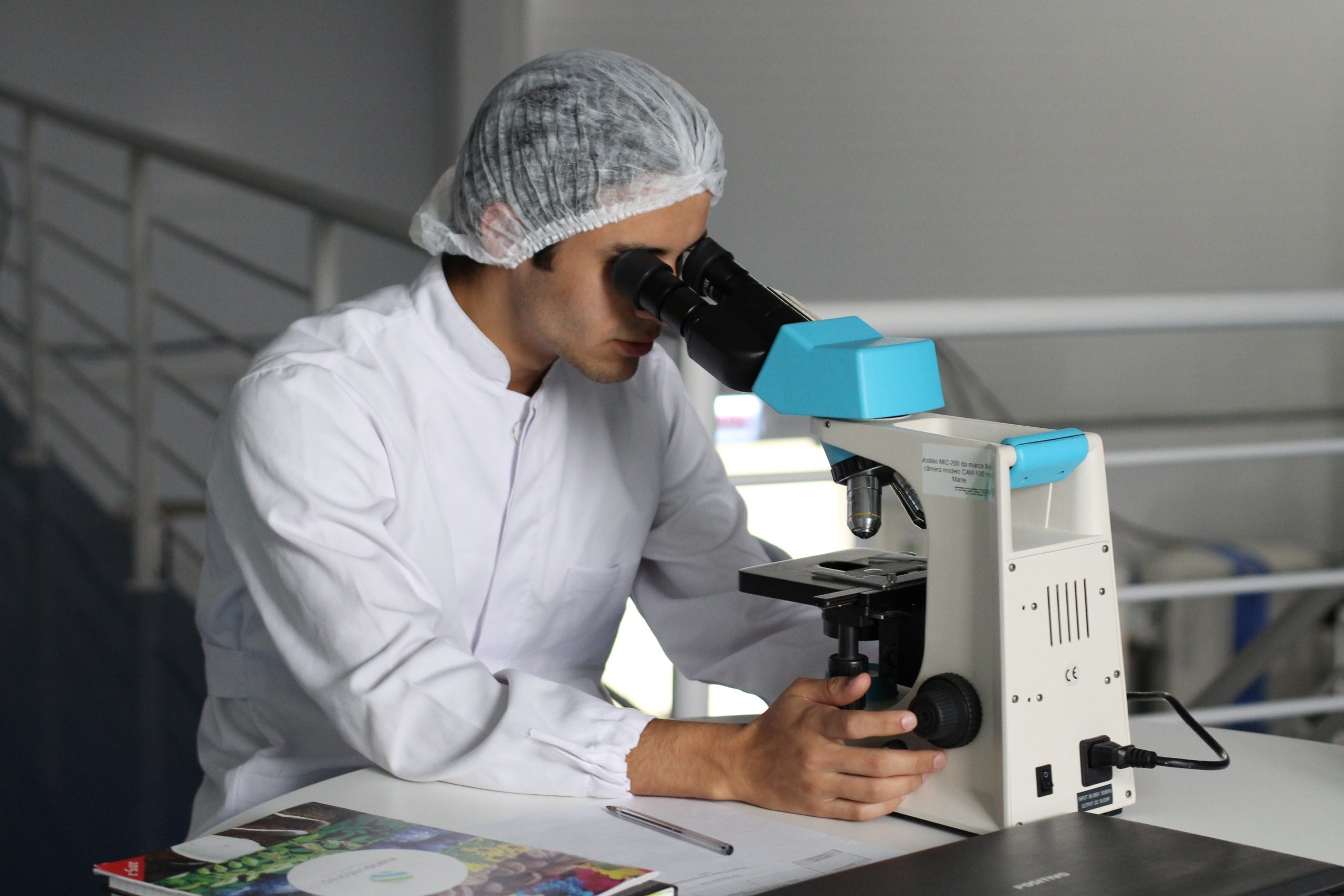 White man using microscope