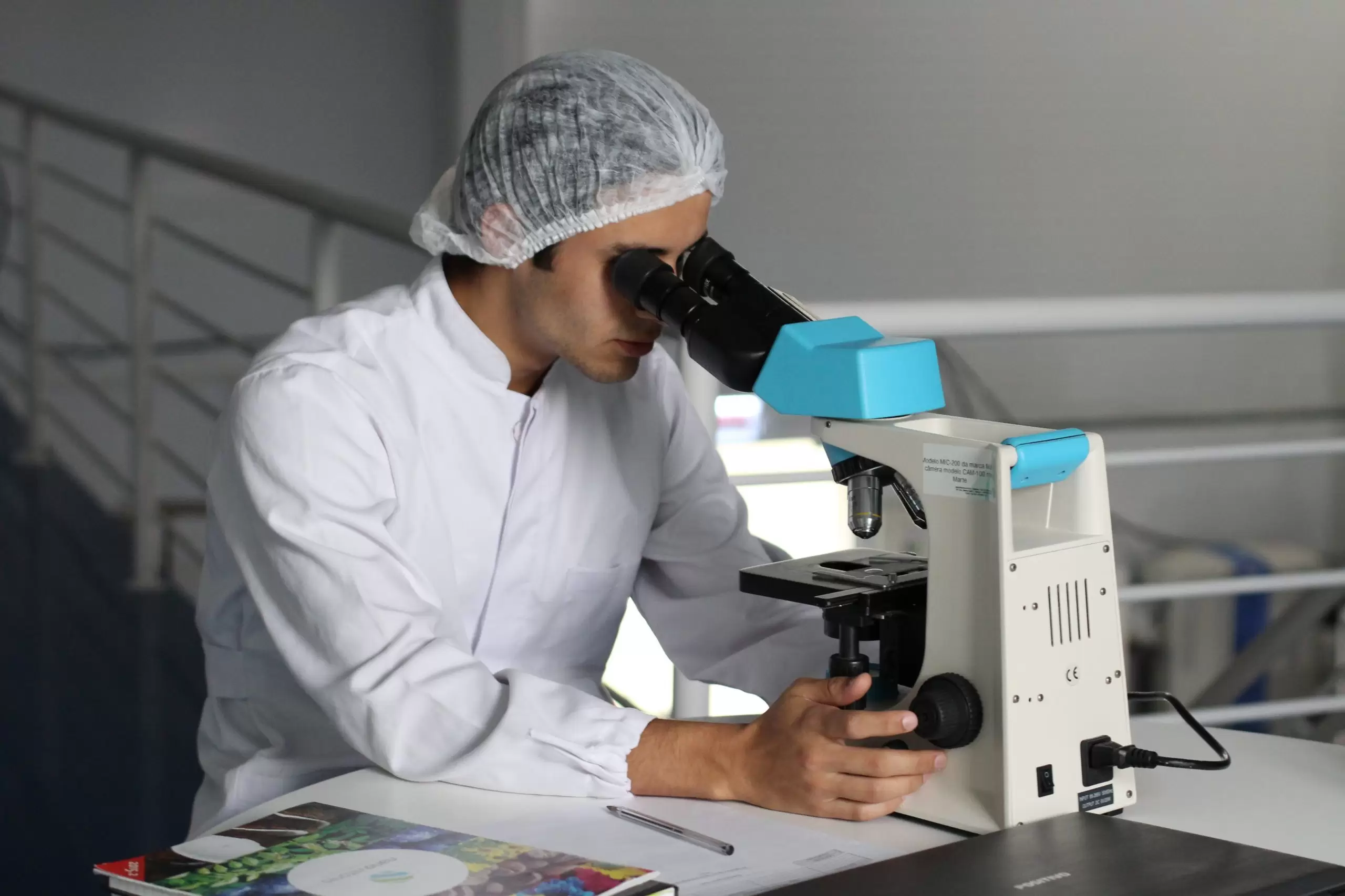 White man using microscope