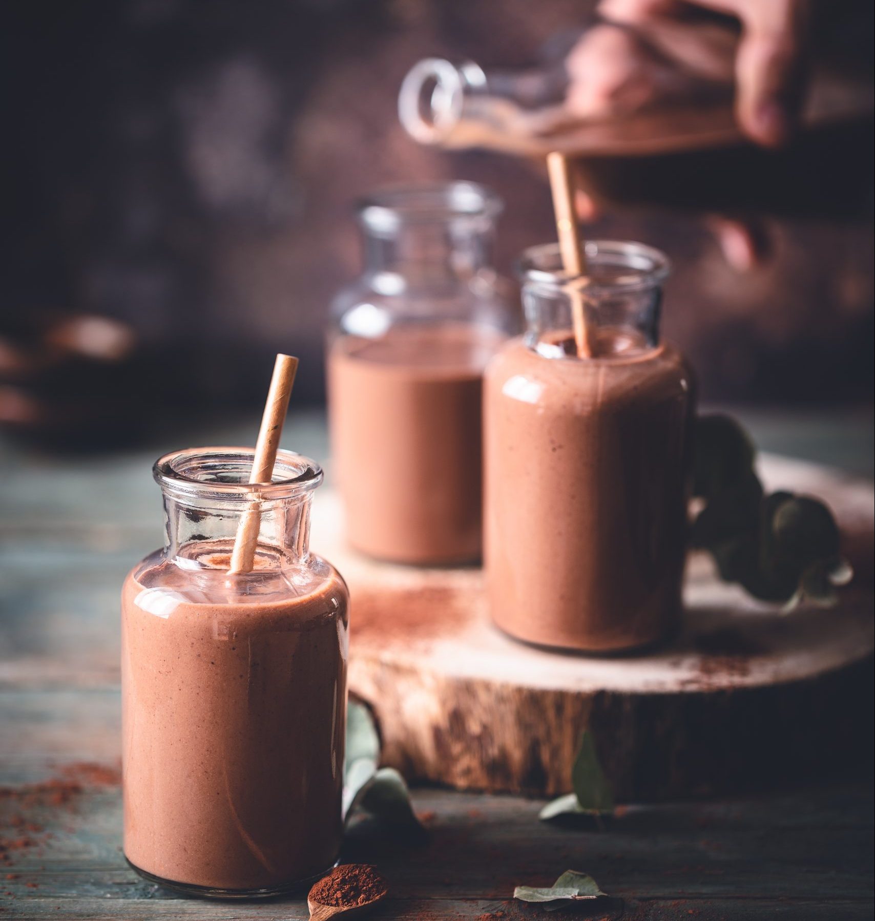 Chocolate milkshake presented in a milk bottle with a straw.