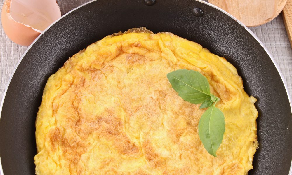 Healthy Omelette in a pan to be cut and served.
