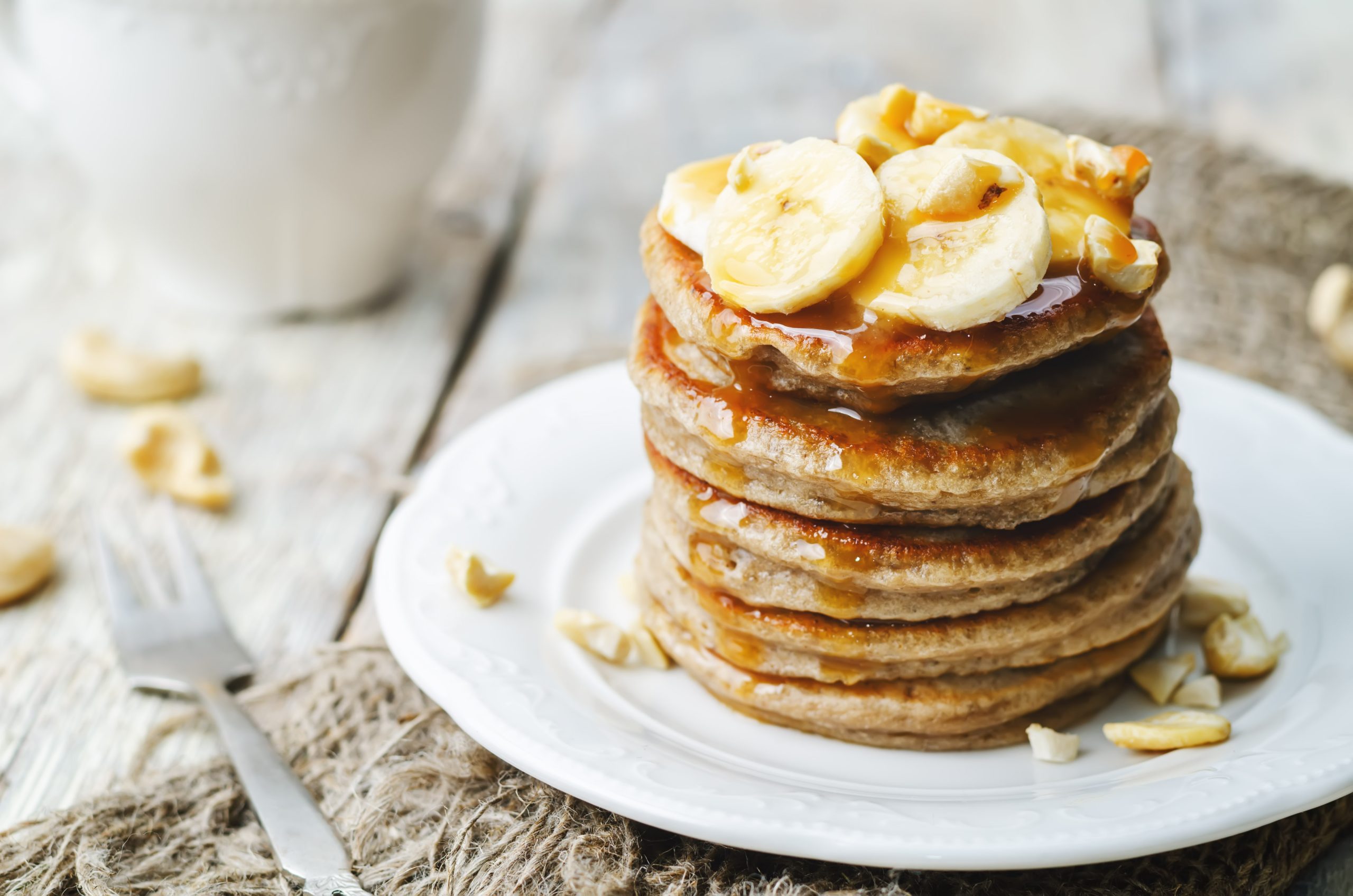 Banana pancakes topped with a sweet sauce and clices of banana, perfect for pancake day.